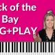 Hot pink background with black and white photo of Otis Redding on the right side. Photo of Brenda Earle Stokes smiling with her hands pointing up. Piano keyboard shown on the bottom of the thumbnail. White lettering reads "Dock of the Bay SING+PLAY"