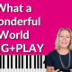 Hot pink background with piano keyboard on the bottom of the thumbnail. Black and white photo of Louis Armstrong singing. Photo of Brenda Earle Stokes in the foreground wearing a navy blue top with an excited look on her face. White lettering reads "What a Wonderful World" SING+PLAY.